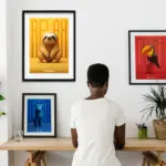 Collective showcase of three framed art prints: a relaxed sloth on yellow, a dreaming jaguar on blue, and a conquering toucan on red, arranged side by side to represent the Colombian flag colors, complete with inspirational phrases and music Spotify codes.